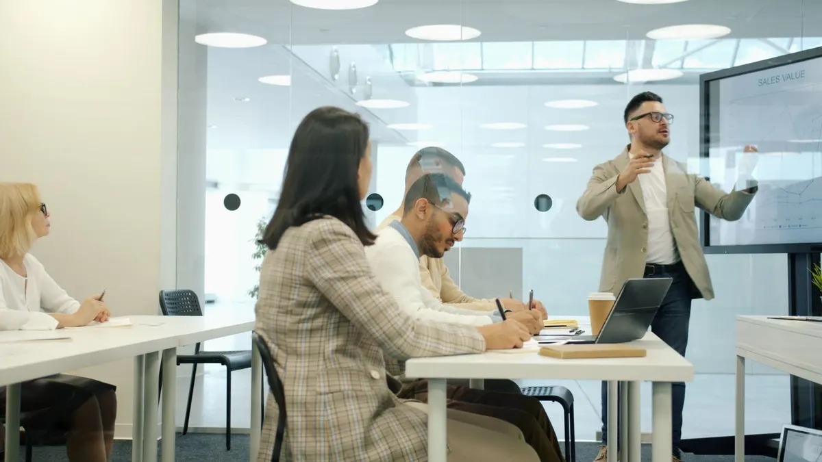 A technical hire working at a laptop surrounded by notes and dashboards in a quiet modern office.