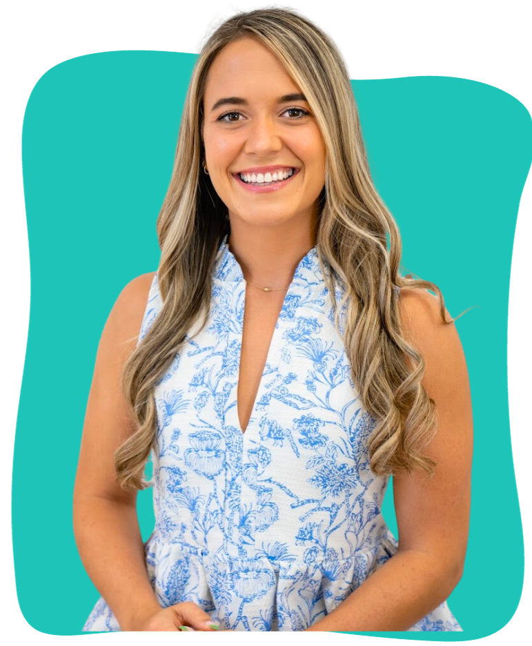 A young woman with long blonde hair and a bright smile wears a white sleeveless dress with a blue floral pattern.