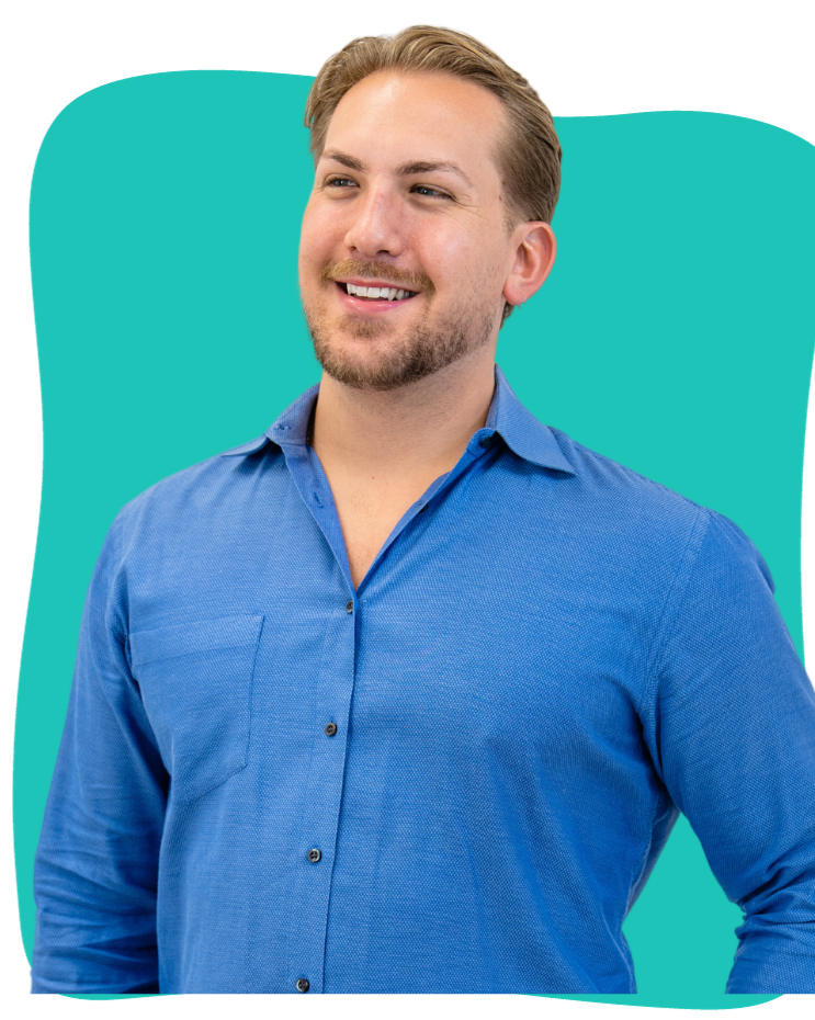 A man with blond hair and stubble in a blue button-up shirt smiles while looking to the left, against a teal background.
